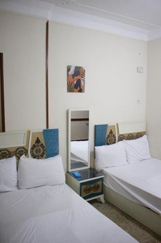 ein Zimmer mit zwei Betten und einem Spiegel in der Unterkunft cairo view hotel in Kairo