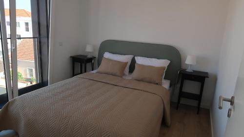 una camera da letto con un grande letto con due cuscini di SottoMayor Best Residence a Figueira da Foz