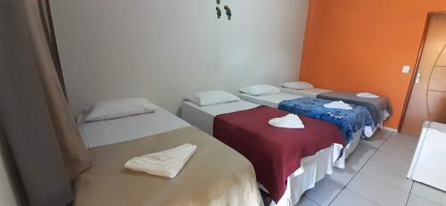 a room with three beds in a room at Pousada Chácara do Coqueiro in Barreirinhas