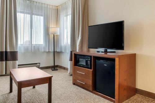a hotel room with a flat screen tv on a entertainment center at Comfort Inn in Manistique