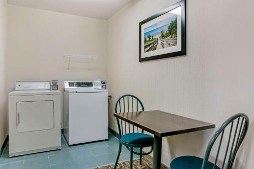 a small kitchen with a table and a washer and dryer at Comfort Inn in Manistique