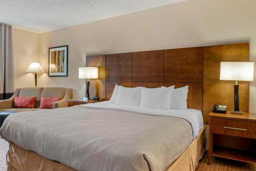 una habitación de hotel con una cama grande y una silla en Quality Inn, en Saint Ignace