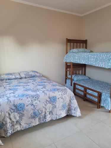 a bedroom with two beds and a bunk bed at Recanto Vó Isabel in Olímpia