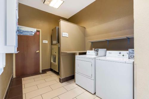 une petite cuisine avec lave-linge et sèche-linge dans l'établissement Quality Suites La Grange, à La Grange