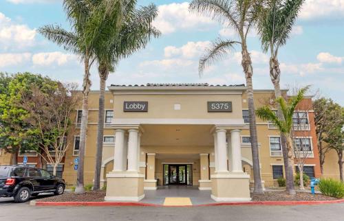 フリーモントにあるExtended Stay America Suites - Fremont - Newarkの建物の前にヤシの木があるホテル