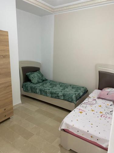 um quarto com duas camas num quarto em Appartement meublé haut standing 2 chambres proche mer em Soliman