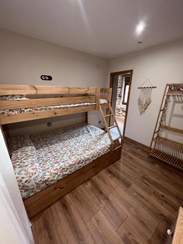a bedroom with two bunk beds and a wooden floor at El Rincón del Val in Priaranza del Bierzo