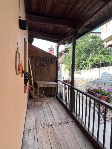 a wooden porch with a bench and a table at El Rincón del Val in Priaranza del Bierzo