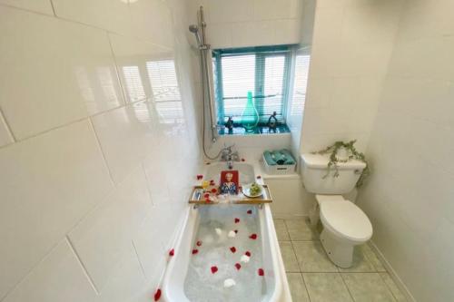 a bathroom with a bath tub in front of a toilet at The Anchor -South Shields in South Shields