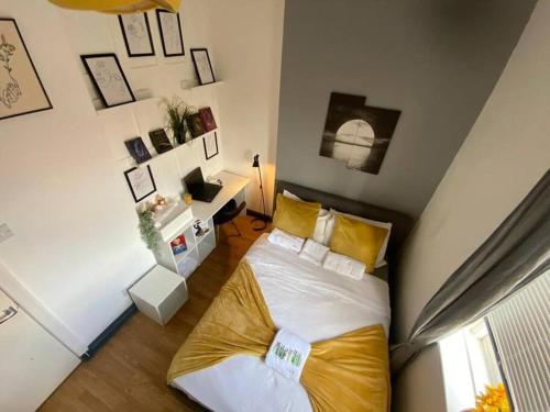 um quarto com uma cama grande e almofadas amarelas em The Anchor -South Shields em South Shields
