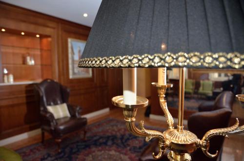 a lamp in a living room with a chair at Albergo Mazzanti in Verona