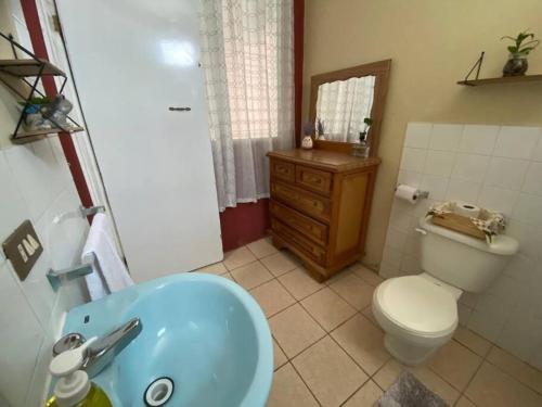 a bathroom with a toilet and a blue sink at Habitación Privada Andrea, en la Isla in Flores