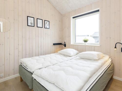 a large white bed in a room with a window at Luxury Retreat in Marielyst - By Traum Ferienwohnungen in Marielyst