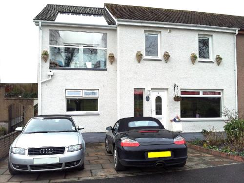 two cars parked in front of a house at Acer Guest House in Perth