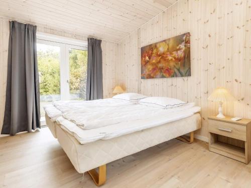 Bøtø ByにあるHoliday home Væggerløse XXXIVのベッドルーム1室(壁に絵画が描かれた大型ベッド1台付)
