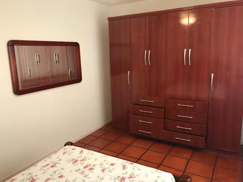 a bedroom with a bed and wooden cabinets at Apartamento Praia do Forte - Cabo Frio in Cabo Frio