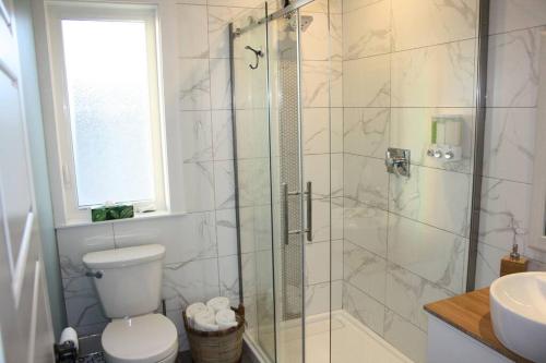 a bathroom with a shower with a toilet and a sink at Luxueux chalet sur la plage - Baie des Chaleurs in Caraquet