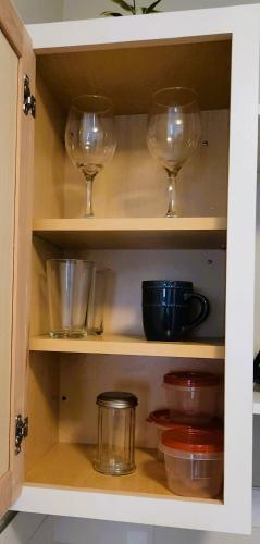 a cupboard with wine glasses and bowls in it at Adorable Mini Suite in Tampa in Tampa