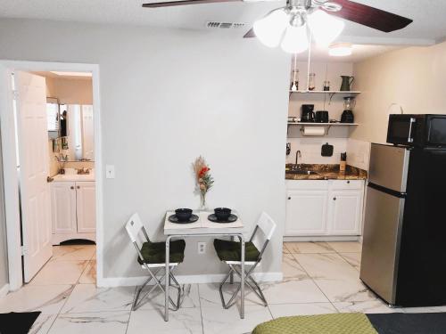 cocina con mesa, sillas y nevera en Adorable Mini Suite in Tampa, en Tampa