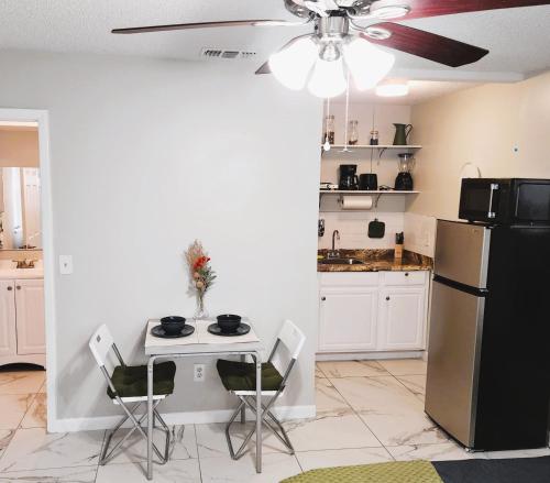 a kitchen with a table and a refrigerator at Adorable Mini Suite in Tampa in Tampa