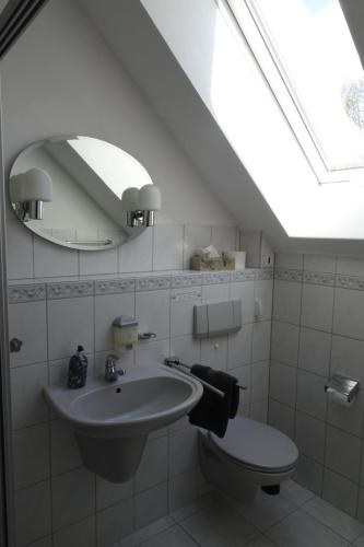 uma casa de banho com um lavatório, um WC e uma clarabóia em Pension Egerer em Bad Köstritz