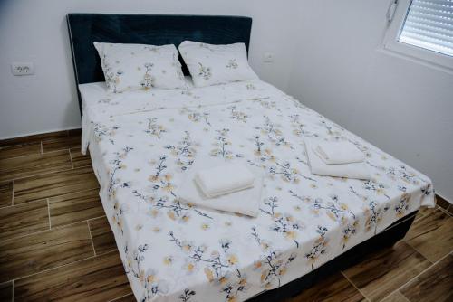 a bed with a white comforter and pillows on it at Premium Apartments in Žabljak