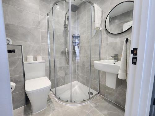 a bathroom with a shower and a toilet and a sink at Paradigm Court, Modern 3-Bedroom Flat 1, Oxford in Oxford