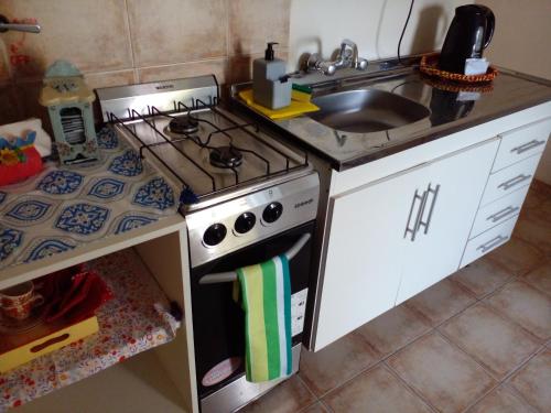 a small kitchen with a stove and a sink at Buenos Aires Tango Apartment near Golf in San Antonio de Padua
