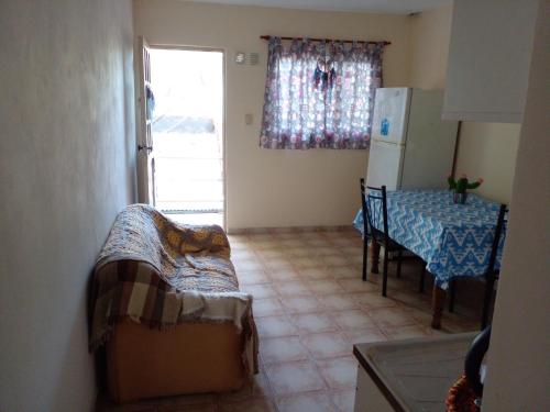 a small kitchen with a table and a refrigerator at Buenos Aires Tango Apartment near Golf in San Antonio de Padua