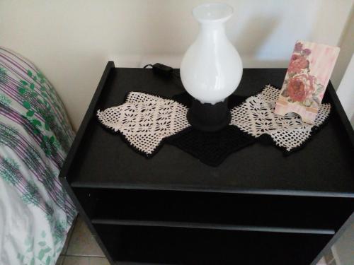 a black dresser with a vase on top of it at Buenos Aires Tango Apartment near Golf in San Antonio de Padua