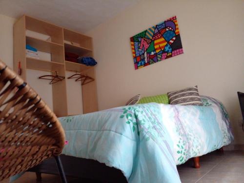 a bedroom with a bed and a painting on the wall at Buenos Aires Tango Apartment near Golf in San Antonio de Padua