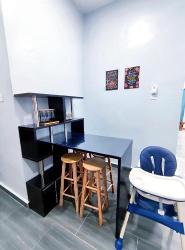 a desk with two chairs and a table with a microwave at Homestay Kuala Terengganu in Kuala Terengganu