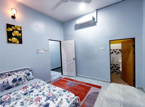 a bedroom with blue walls and a bed and a mirror at Homestay Kuala Terengganu in Kuala Terengganu