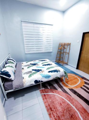 a bedroom with a bed and a rug at Homestay Kuala Terengganu in Kuala Terengganu