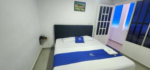 Un dormitorio con una cama con un teléfono. en Hotel Noz INN, en Villavicencio