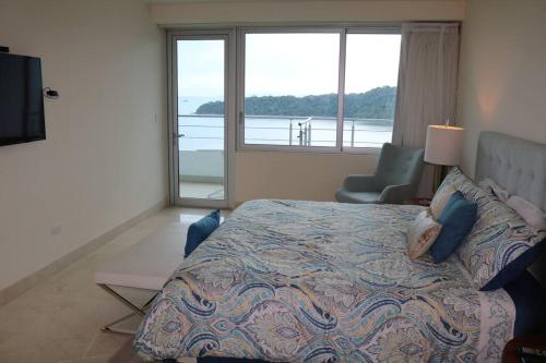 a bedroom with a bed with a view of the water at 13B Spectacular Oceanview Resort Lifestyle Panama in ArraijÃ¡n