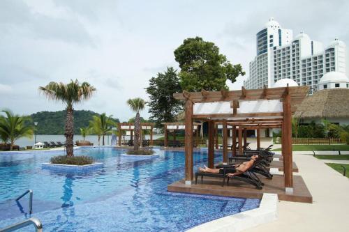 un hombre tendido en una silla en una piscina en un resort en 13B Spectacular Oceanview Resort Lifestyle Panama, en ArraijÃ¡n