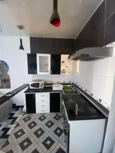 uma pequena cozinha com uma cozinha a preto e branco em Port kantaoui em Tunes