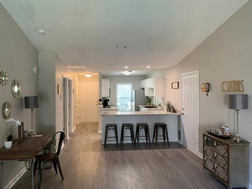 a kitchen and living room with a counter and stools at Comfy, Stylish Townhome Near I-20! in Augusta
