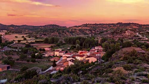 ein Dorf in den Hügeln bei Sonnenuntergang in der Unterkunft Las Golondrinas de Henche 