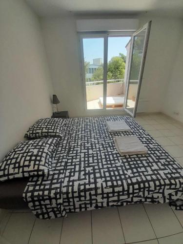 a large bed in a room with a large window at T2 duplex + piscine avec parking in Montpellier