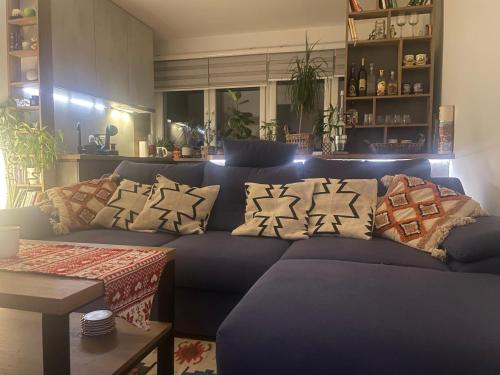 a blue couch with pillows on it in a living room at Wild Green in Sarajevo