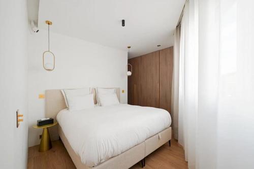 a bedroom with a large white bed with white sheets at Appartement 4 pièces / 8 couchages in Neuilly-sur-Seine