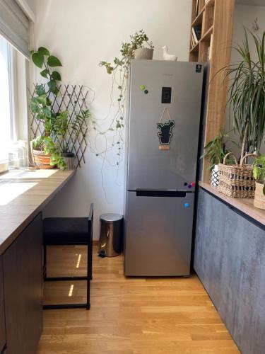 een koelkast in een keuken naast een aanrecht met planten bij Wild Green in Sarajevo