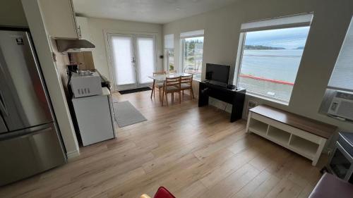ein Wohnzimmer mit einer Küche und einem Tisch mit Meerblick in der Unterkunft Penthouse in Bowser