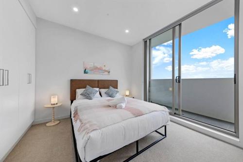 1 dormitorio con cama y ventana grande en Entire Apartment in Ryde, en Sídney