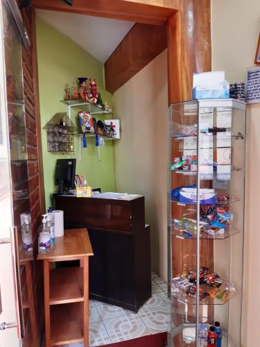 Hostal Vista al Lago Titicaca Puno في بونو: غرفة مع مكتب ورف زجاجي