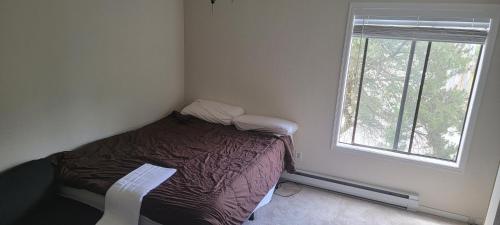 a small bedroom with a bed and a window at Ayman in Seattle