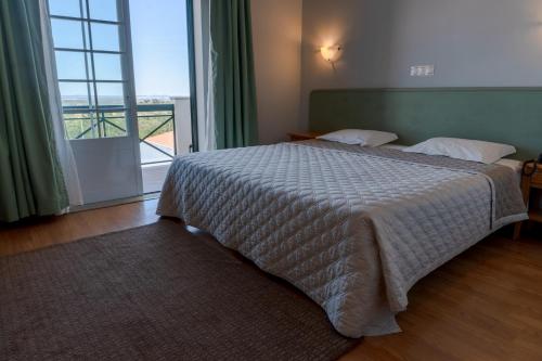 um quarto com uma cama e uma janela grande em Hotel Estrela Da Idanha em Idanha-a-Nova