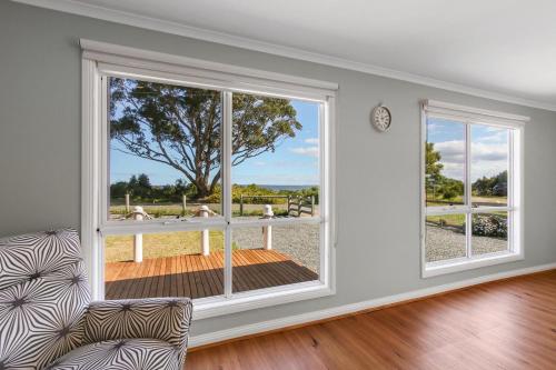 a living room with a large window and a chair at Sunseeker on Tambo in Metung